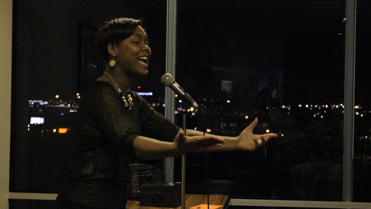 一位非裔美国妇女在麦克风之夜朗诵一首诗